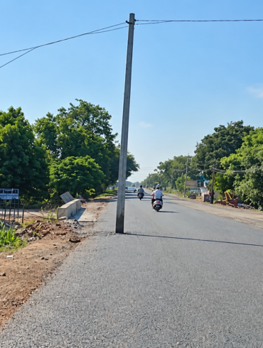 An electric pole obstructs a newly tarred road in Ballari, sparking safety alarms