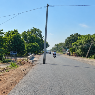 An electric pole obstructs a newly tarred road in Ballari, sparking safety alarms